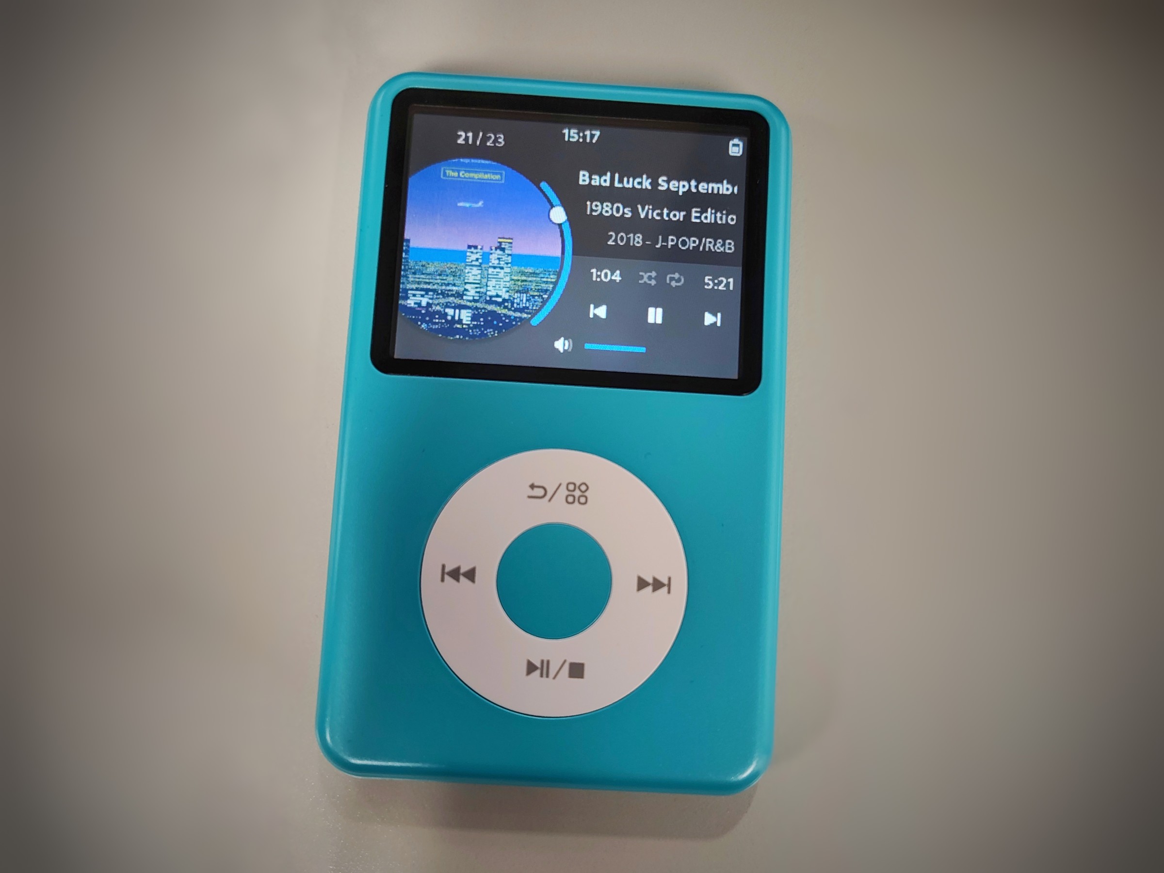 My Innioasis Y1, teal colored, running Rockbox with the Satellite theme on it.